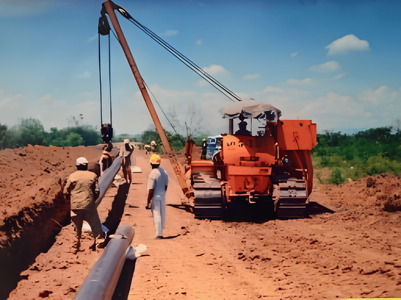 Pipe laying with a crawler crane during oil pipeline construction