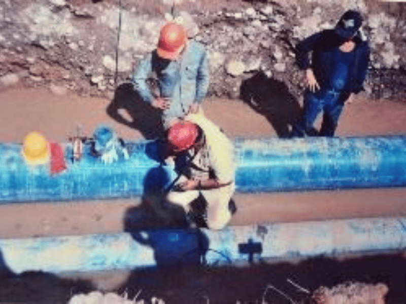 Workers assembling pipe sections in the installation trench