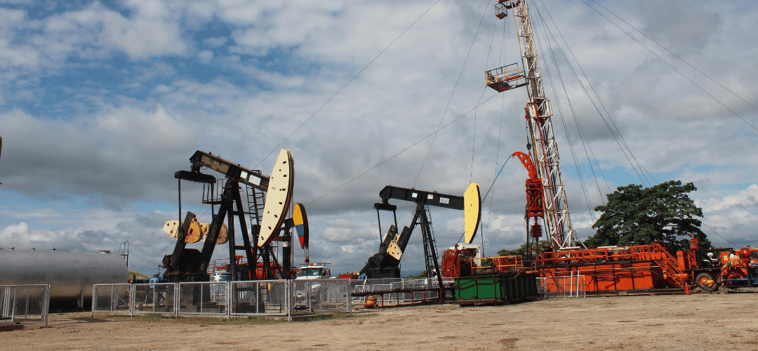 Oil field with pump jacks and a workover rig