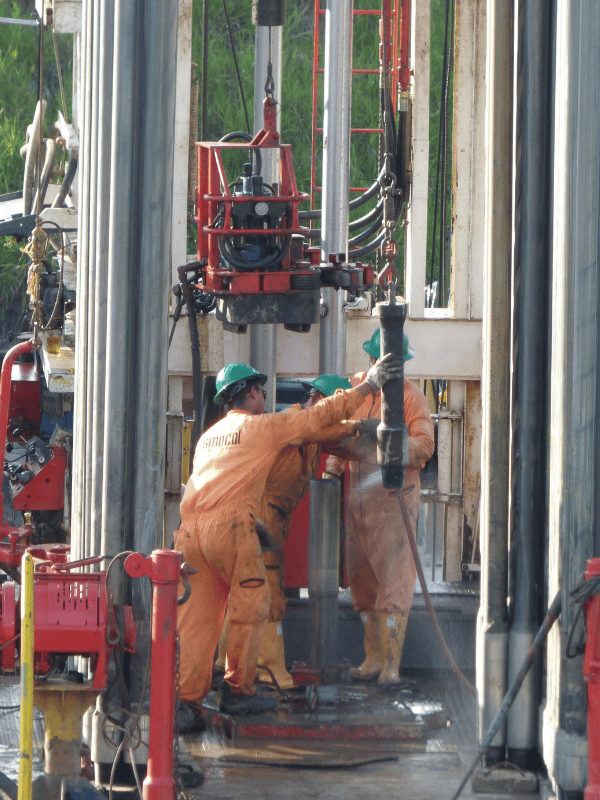 Technician operating equipment on a drilling rig floor