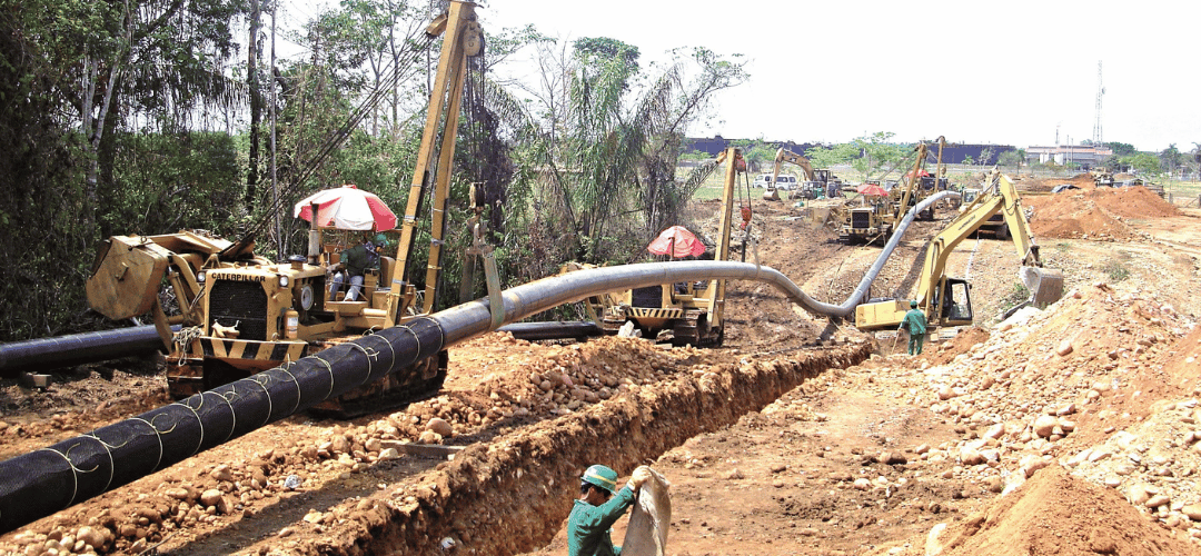 Construcción de línea de tubería con cuadrilla y maquinaria en zanja abierta